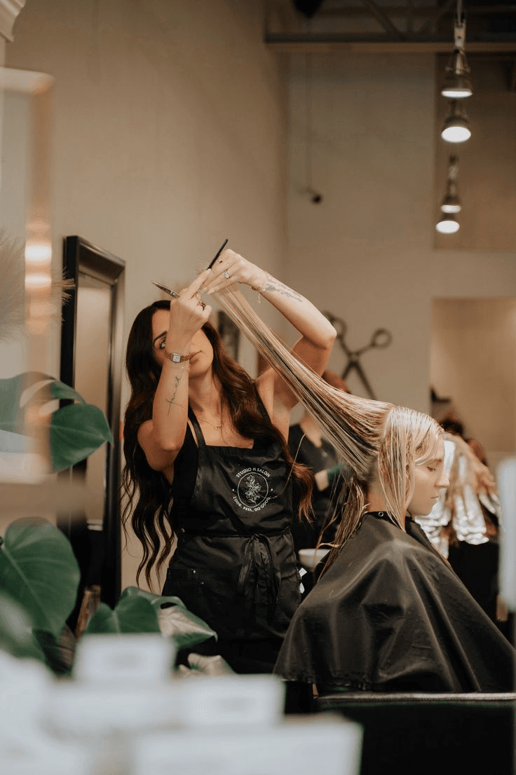 Salon stylist working on client's hair